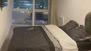 Une chambre à coucher avec un lit, une fenêtre et une vue sur l’extérieur.