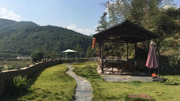 A gazebo with a stone pathway leading to it, surrounded by lush greenery and a mountainous backdrop. - Mogan Mountain Yaonanwu Manor (Deqing)