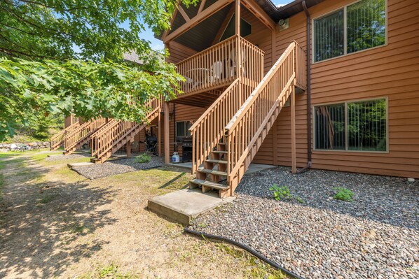 A wooden cabin with a balcony and a staircase leading to the upper level.