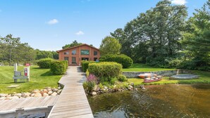 A wooden dock leading to a building with a sign that reads "Chateau de St. Louis." - Causeway on Gull (Nisswa)