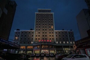 A multi-story hotel with a prominent entrance and signage. - Huchuan Hotel (Yueqing)