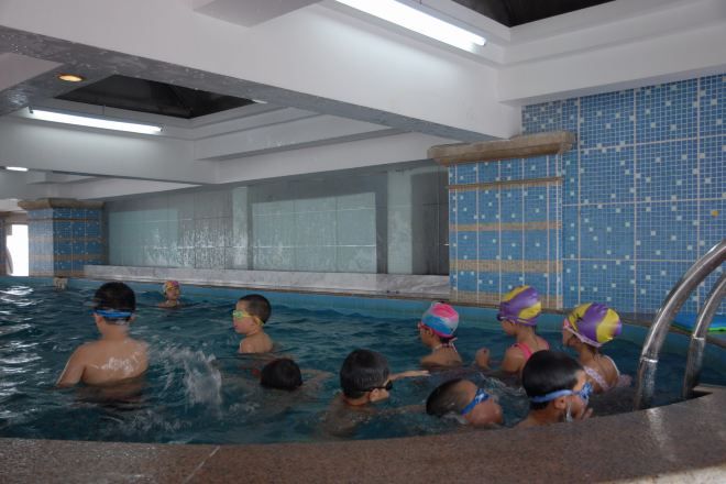 Piscina interna com paredes azulejadas e vista clara da área da piscina.