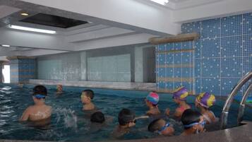 Piscina interna com paredes azulejadas e vista clara da área da piscina.