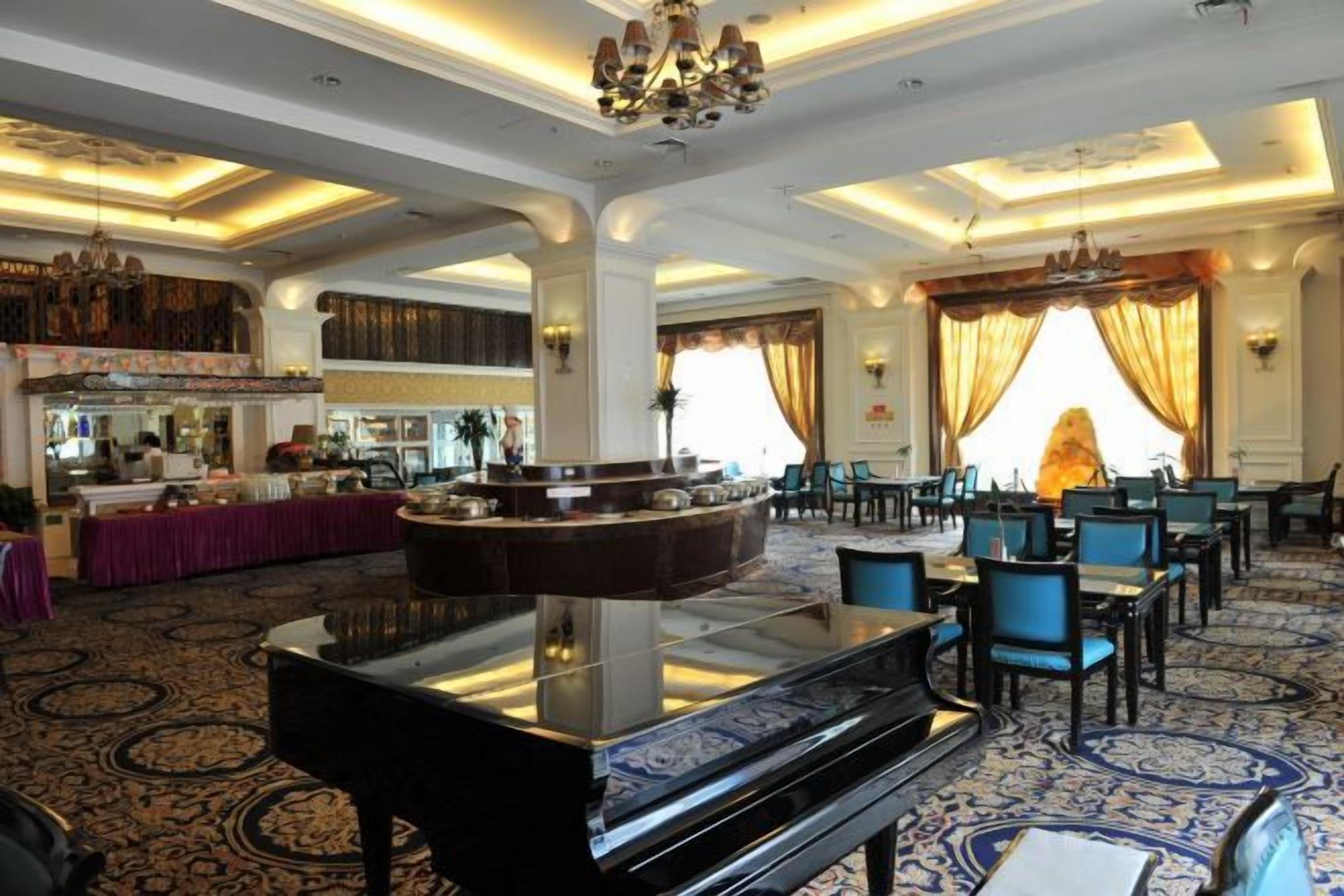 A grand lobby with a grand piano, a bar area, and a seating arrangement for guests.