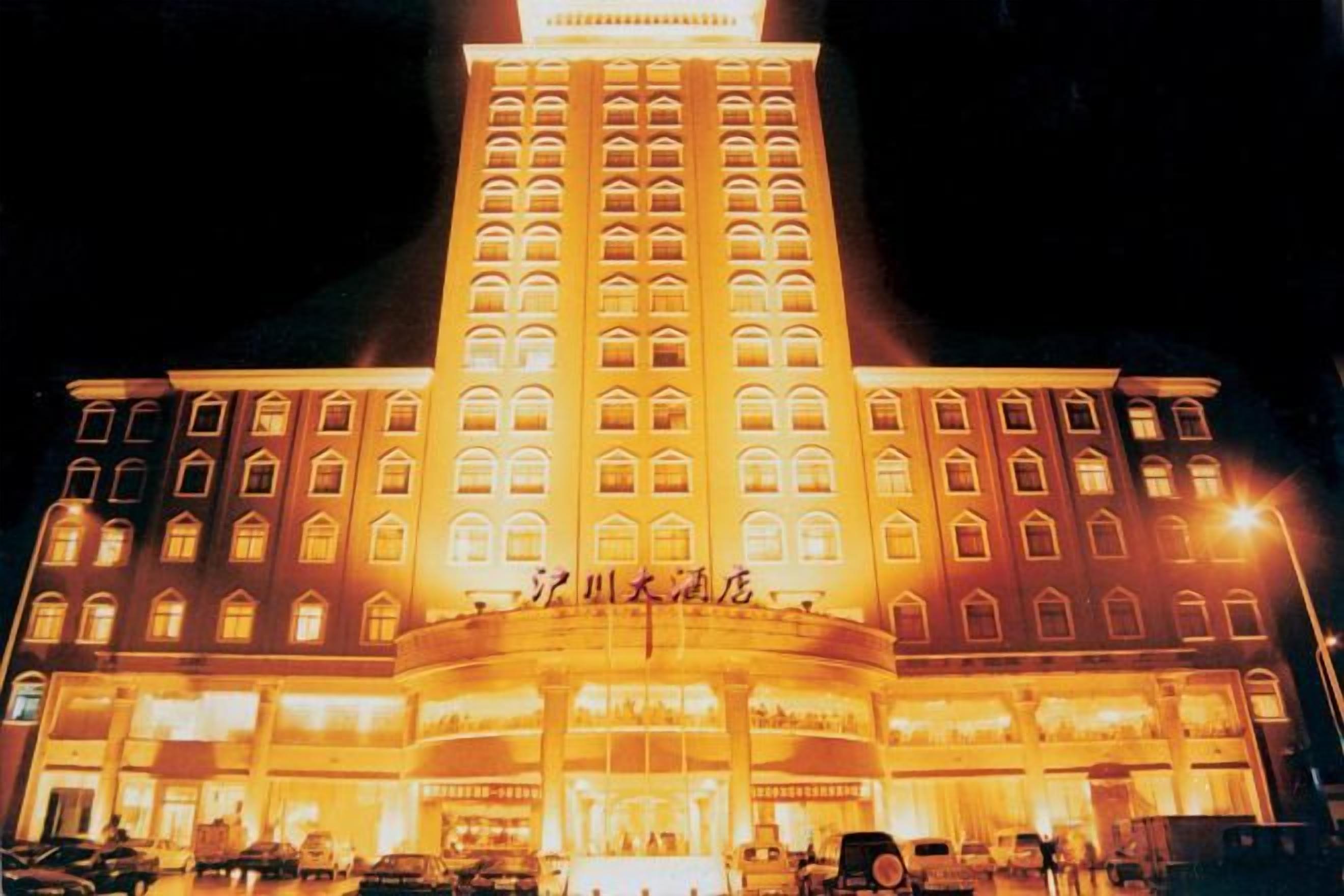 A multi-story hotel with a prominent entrance and illuminated signage.