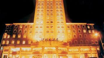 A multi-story hotel with a prominent entrance and illuminated signage.