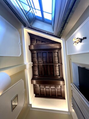 A room with a skylight, a dark wooden panel wall, a fireplace, and a television. - Veronica Suite – Historic Center near Piazza Venezia (Roma)