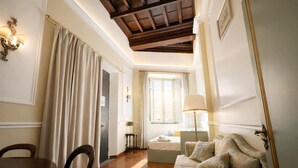 Une pièce avec un plafond en bois, un lit doté d’une tête de lit blanche, un canapé, une table et des chaises.