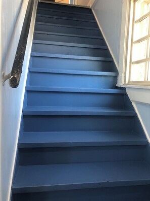 A set of blue stairs leading to a landing.