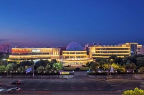 A hotel with a prominent dome structure, multiple floors, and a well-lit entrance. - Cixi Hangzhou Bay International Hotel (Cixi)