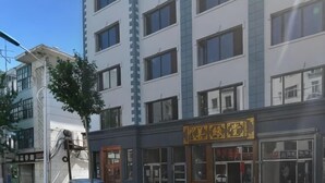 A multi-story building with a storefront featuring a yellow sign. - Heihe Bianguan Mingyue Hotel (Heihe)