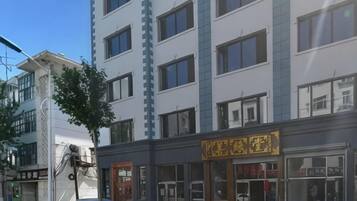 Ein mehrstöckiges Gebäude mit einer Schaufensterfront und einem gelben Schild.