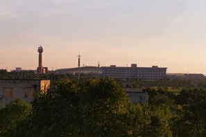 Un edificio con una torre, rodeado de árboles y otras construcciones.