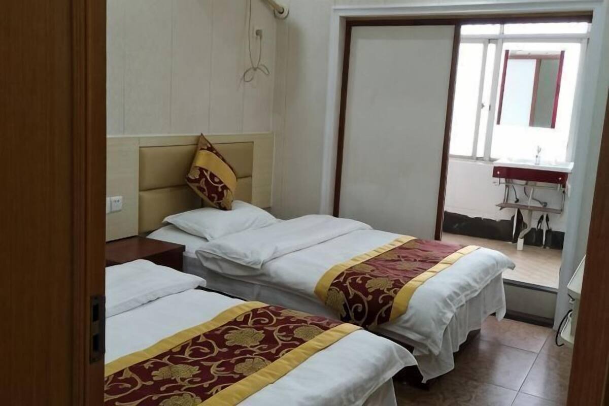 Habitación de hotel con dos camas, baño y vistas al exterior.