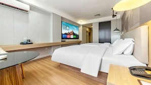 Una habitación de hotel moderna con una cama, un escritorio, un televisor y una lámpara.