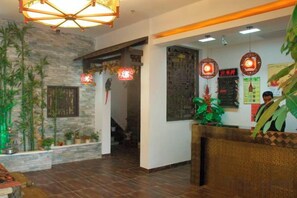 A reception area with a reception desk, a staircase, and decorative plants. - Harbin Cashbox Express Hotel (Harbin)