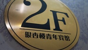 En rund skylt med siffran ”2F” och kinesiska tecken.