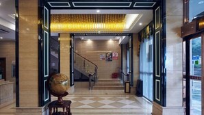 A hotel lobby with a checkered floor, a staircase, and a globe sculpture. - WP Guo Creative Hotel (Cangnan EMU Station Store) (Cangnan)
