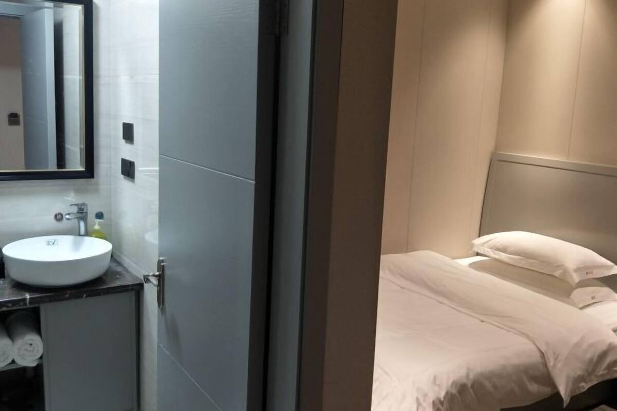 A modern bathroom with a round sink, a mirror, and a toilet.