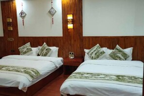 A hotel room with two beds, wooden headboards, wall-mounted lamps, and a nightstand with a phone. - Pu'er Shihoude Inn (Pu'er)