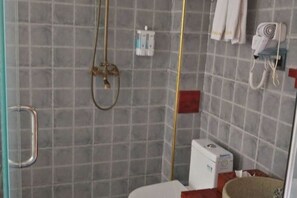 A bathroom with a shower, a toilet, and a sink. - Pu'er Shihoude Inn (Pu'er)