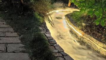 A stone pathway leading to a water feature with a curved design.