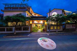 A traditional building with a prominent entrance, a balcony, and a well-lit facade. - Pu'er Shihoude Inn (Pu'er)