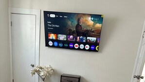 Une chambre à coucher comprenant un lit, un téléviseur fixé au mur qui affiche l’interface d’un service de diffusion en continu, une petite armoire et une porte.