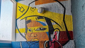 A colorful mural with abstract patterns and shapes. - Hotel Velero Sur (Iquique)