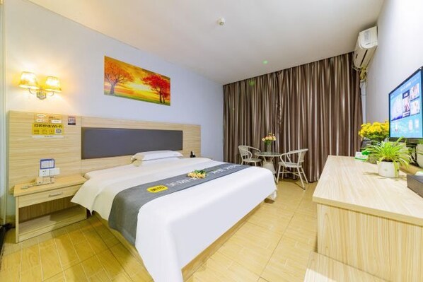 A hotel room with a bed, bedside table, desk, chair, and a TV. - SWT(sweetheart) Express Hotel (Dongguan)