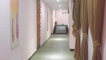 A hallway with a staircase leading to an upper floor.