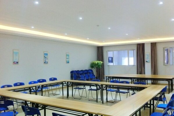 A conference room with a large table, blue chairs, and a potted plant. - SWT(sweetheart) Express Hotel (Dongguan)