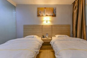 A hotel room with two beds, a wooden headboard, a painting on the wall, and a nightstand with a phone and a lamp. - SWT(sweetheart) Express Hotel (Dongguan)
