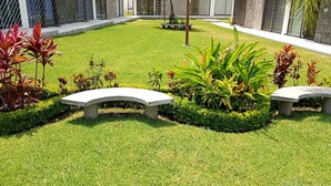 A well-maintained garden with two stone benches and a variety of plants. - Beautiful and Spacious House Alcatraz, Florencia Gardens, Cuernavaca (Cuernavaca)