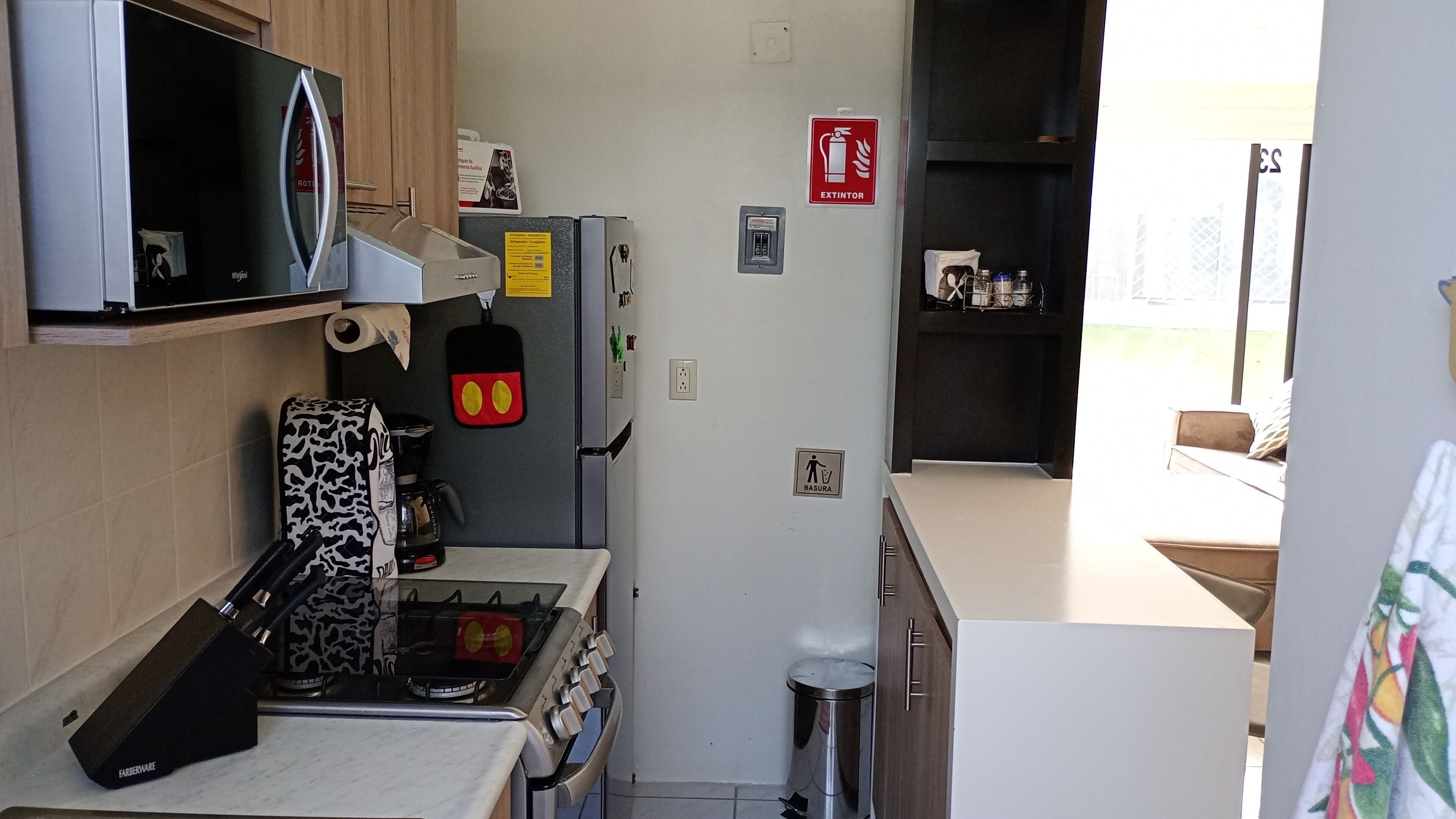 A compact kitchen with a stove, microwave, and refrigerator.