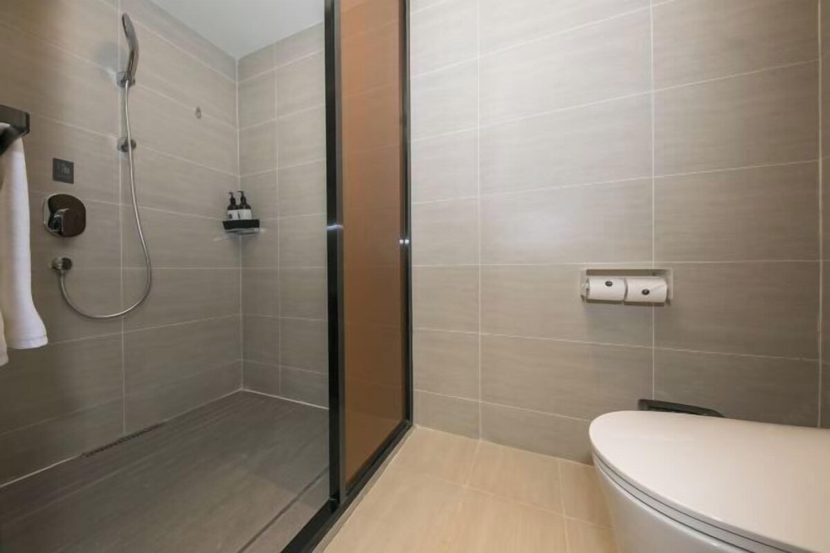 Ein modernes Badezimmer mit Duschkabine, Toilette und Handtuchhalter.