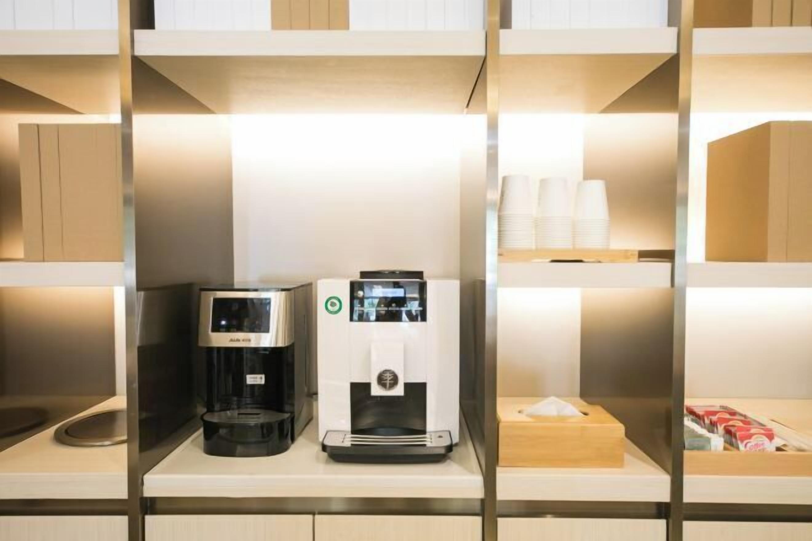 Une machine à café et un distributeur d’eau sont posés sur une étagère dans une chambre d’hôtel.