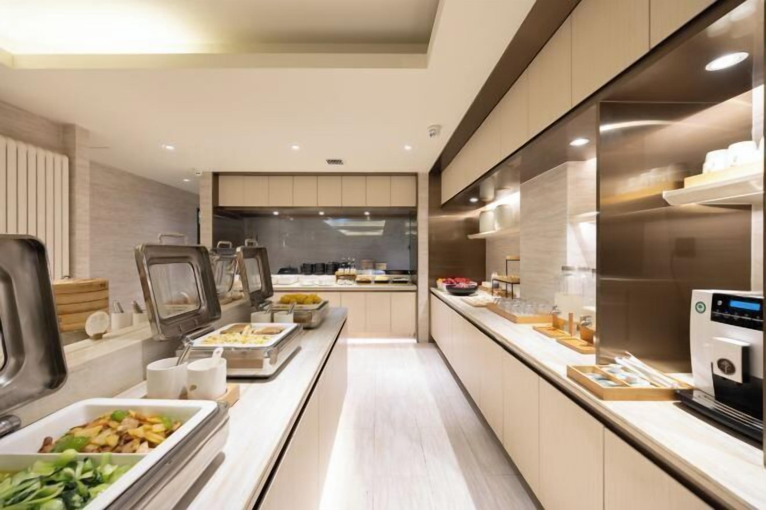 A modern buffet setup with various food stations and a coffee machine.