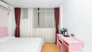 Een slaapkamer met een bed, bureau en raam met gordijnen.