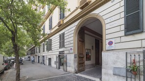 A building with a large arched entrance, a sign indicating a no parking zone, and a sign for a medical facility. - Elegant Apartment in the Heart of Prati with Comfortable Rooms (Roma)