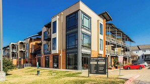 A multi-story building with a modern architectural design, featuring large windows and balconies.