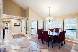 A dining area with a table, chairs, and a chandelier. - Waterfront Home on Lake Travis (Lakeway)