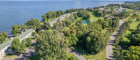 An aerial view of a coastal resort with multiple buildings, a golf course, and a lake.