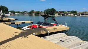 Un bateau était amarré à un quai doté d’une plateforme en bois, d’un espace de repos abrité et d’une vue dégagée sur l’eau et les maisons environnantes.