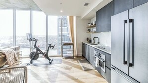 Een moderne keuken met een grote koelkast, een eethoek met uitzicht, en een fiets in de hoek.