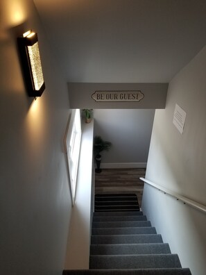 A staircase with a sign that reads "BE OUR GUEST" and a small sign with text below it.