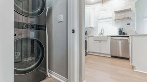 A modern kitchen with stainless steel appliances, white cabinetry, and a built-in dishwasher. - South Austin 2BR | Close to SoCo/Zilker | Sleeps 4 (Austin)
