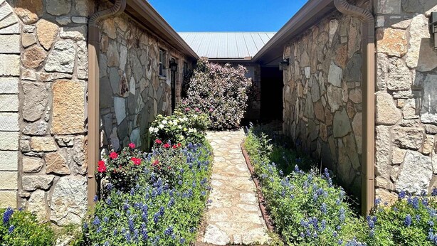 A stone building with a stone pathway leading to a covered entrance.