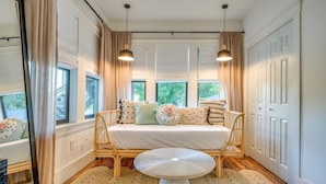A room with a bed, a small table, and a window with curtains.