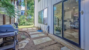 A patio with a barbecue grill, stone stepping stones, and a garden.